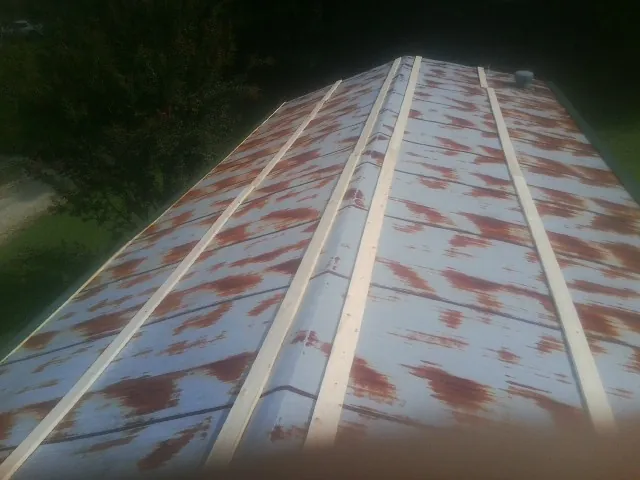 Rusted metal roof panels with new wood purlins before replacement — Storm Damage Roof Repair in Alexandria by Roofing Brothers